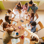 High angle view of elementary teacher having an art class with group of her students in the classroom.